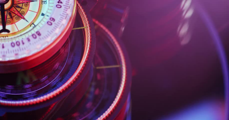 Stacked compasses with a wind rose on the face spinning and needle rotating