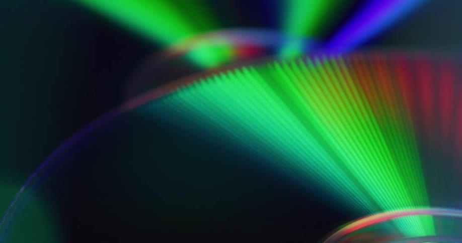 Discs covered in sections of rainbow colors light up as colored lights fill the darkness
