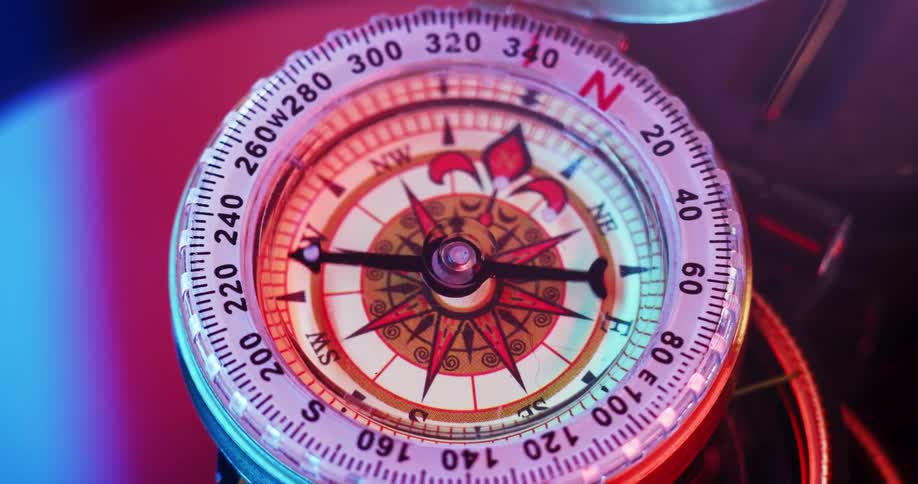 The hand on the dial of a compass is moving around