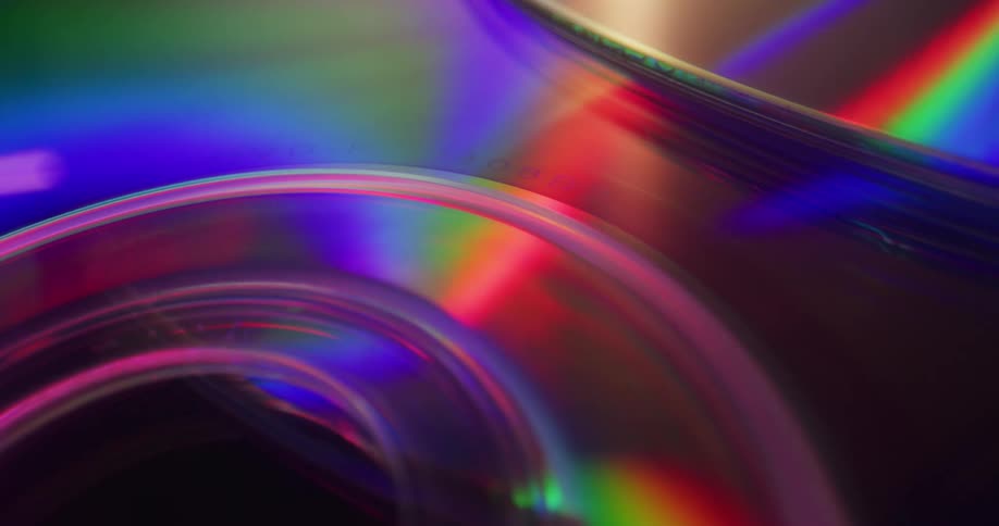A rainbow of color shimmers on the surface of compact discs
