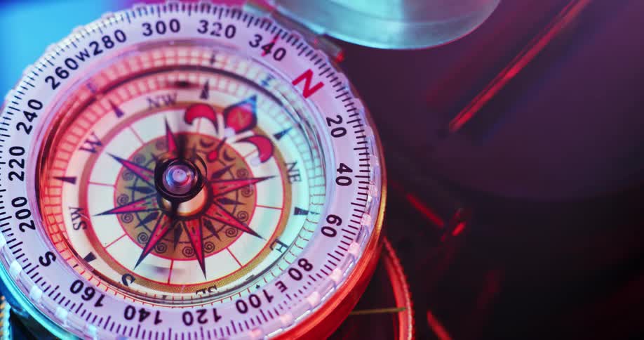 A compass with a wind rose on its face and a spinning needle