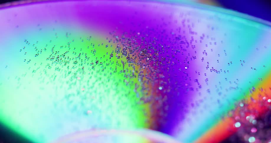 A dark glittery disc is moving as colored light beams rotate and follow the movement