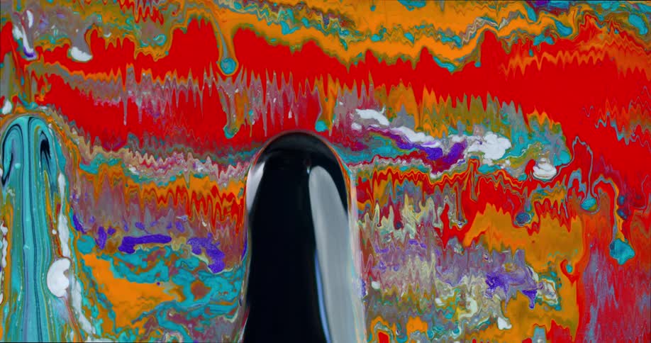 Lines of colored liquid are dripping and blending downward as wider blobs of color are quickly moving upwards