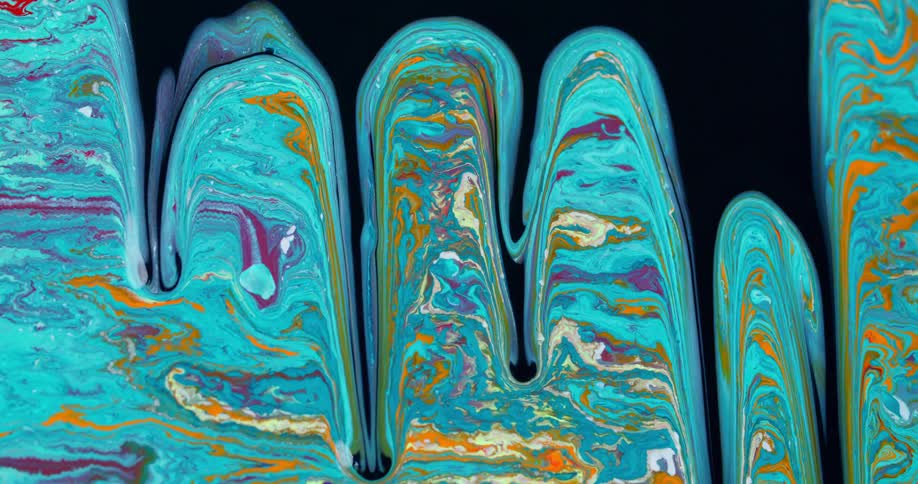Paint drips down a canvas cutting through light blue and colorful paint