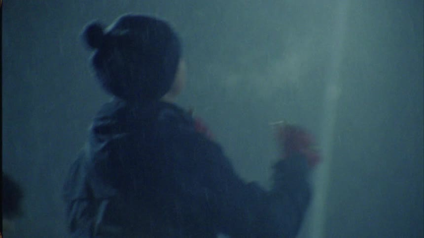 A group of teenagers are outside playing with a ball in the snow
