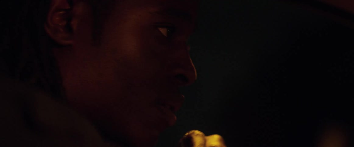 A young black male concentrates on the road ahead of him while driving