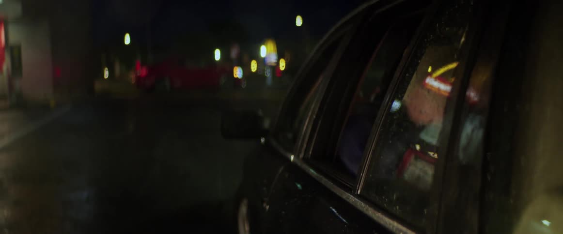 Teenage boys are driving around in an automobile and a boy in the back seat opens the door and another person gets in the vehicle