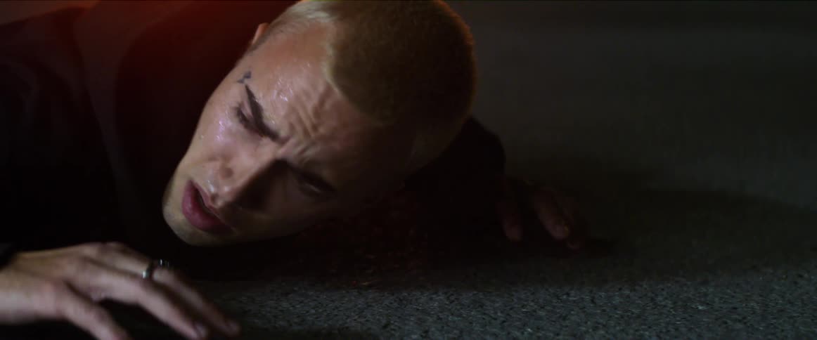 A man is laying with his hands face down on the pavement