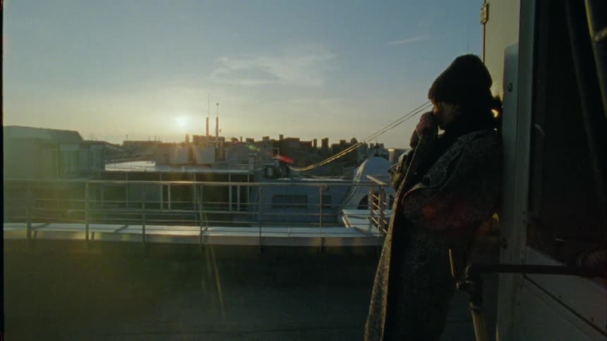 A woman is on the roof watching the sunrise