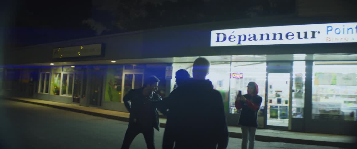 Two men argue in a street and another man tries to break up while a teenager videos the fight the man then goes after him and pulls a gun on everyone