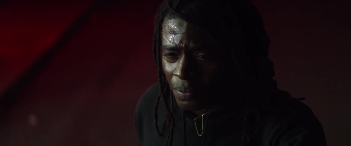 A young man sweating and crying out in fear and pain on the street at night