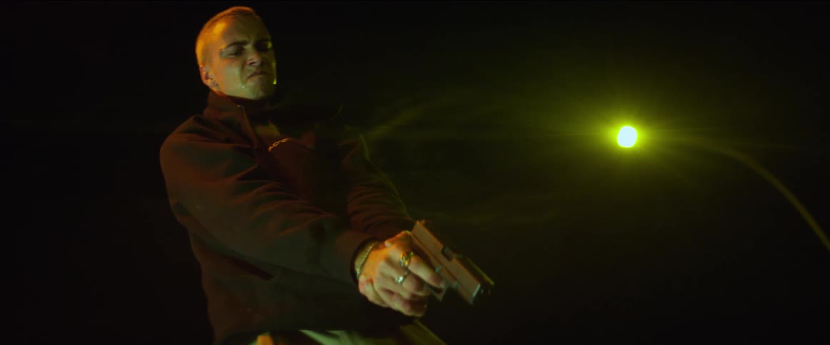 A man pointing a gun at someone at night