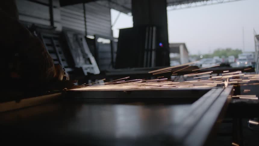 Sparks fly as a man is using a machine to work with metal