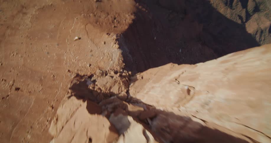 A narrow mesa sits high above the ground in a canyon