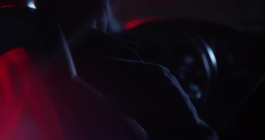 A man gets in a car at night