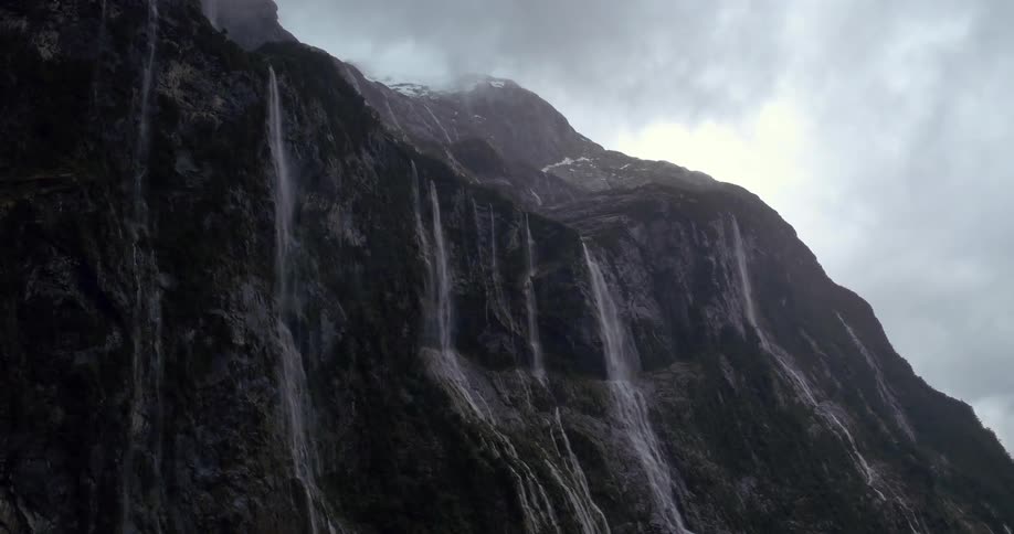 Waterfalls gush over a steep cliff in the mountains