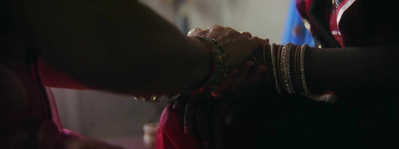 A woman pats another womans hand and holds on to it