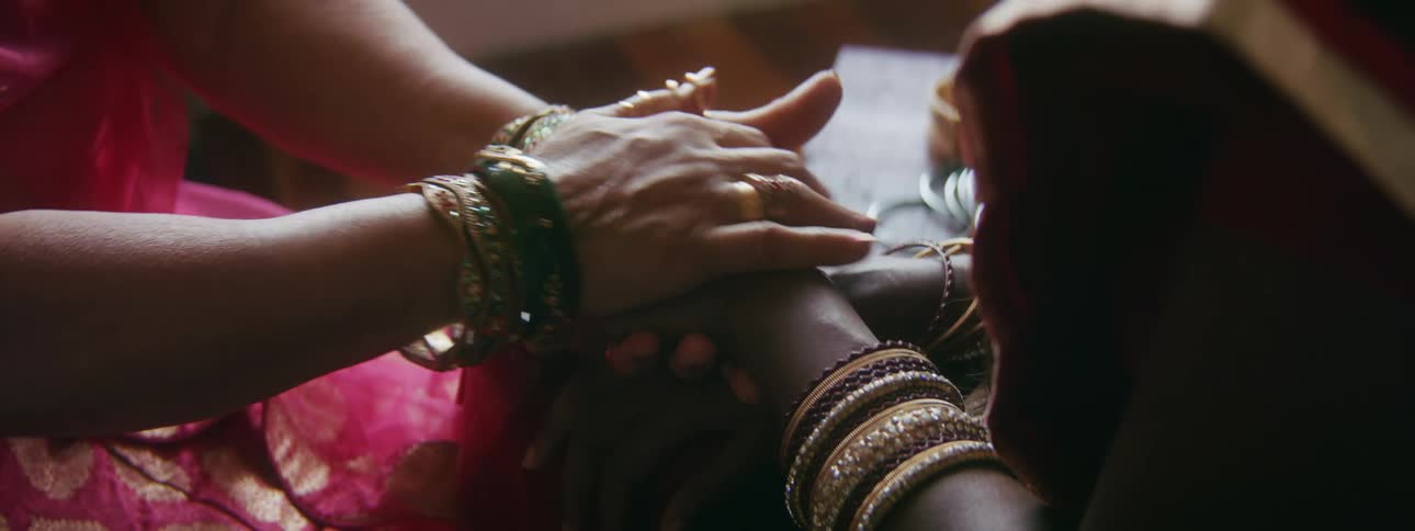 Woman holds another womans hands stroking it
