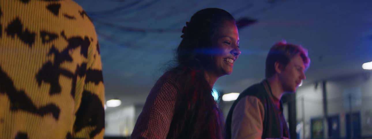 Friends hold hands while moving across rink in concert