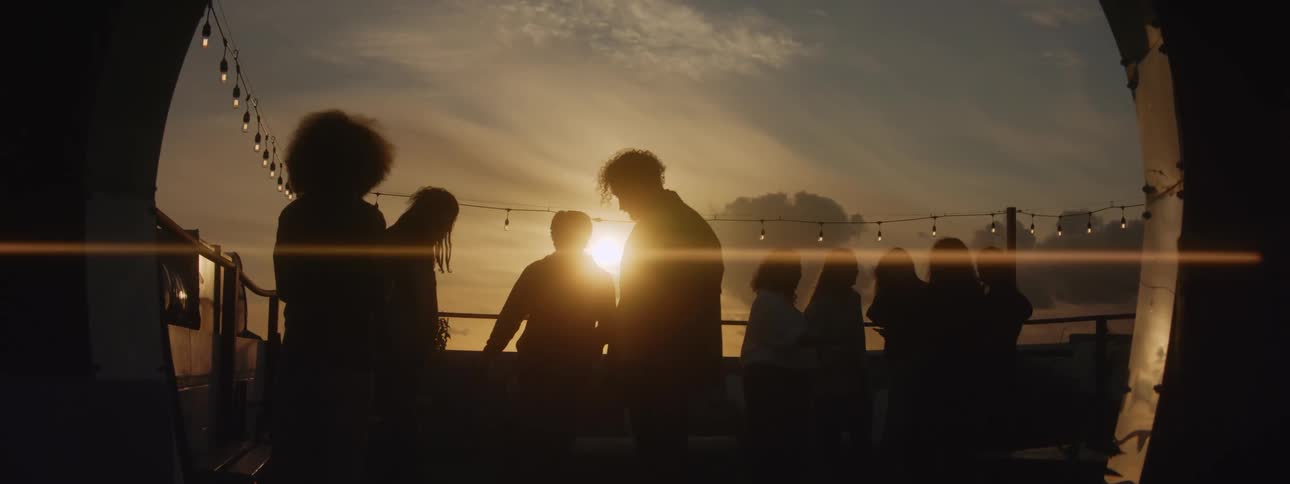 Sun shines from just above the horizon silhouetting party attendees