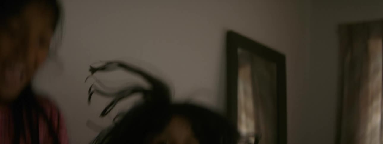 Two young girls are jumping and playing and their hair bounces as they move up and down