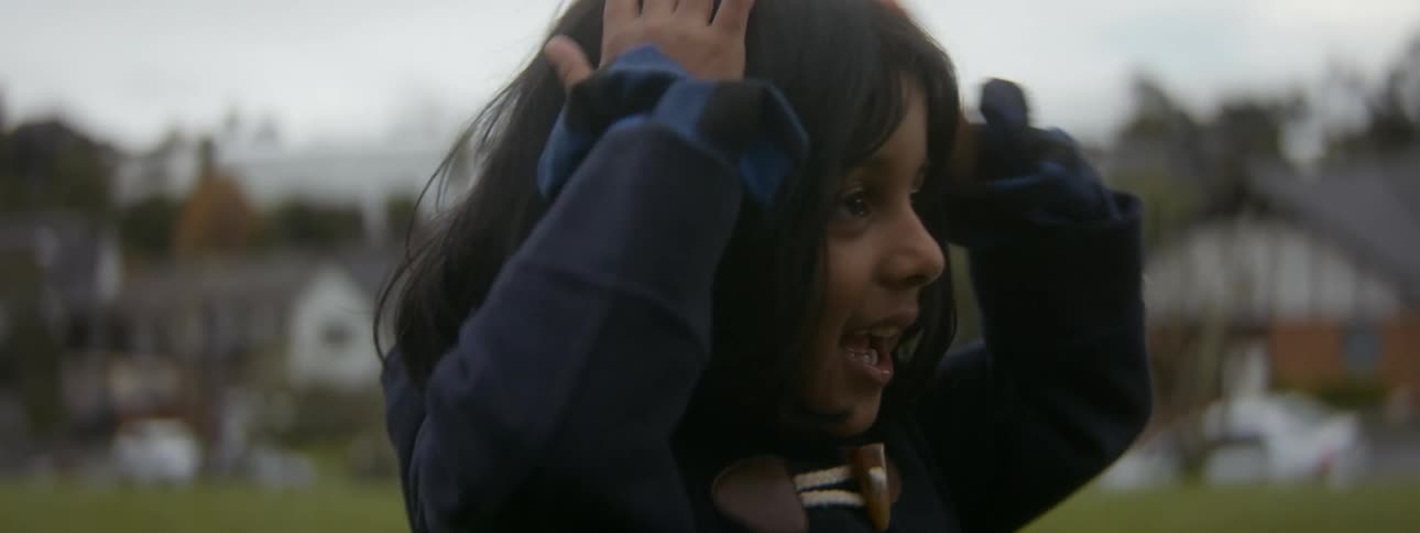 Close up of the head of a young girl playing on a park in the neighborhood at evening