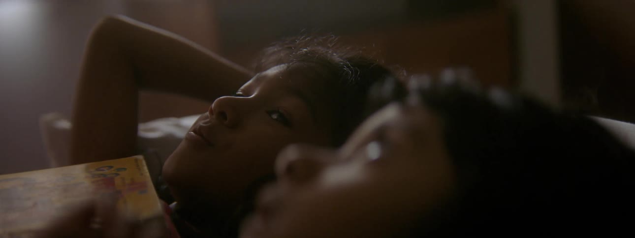 Siblings lie in bed together and stare at the ceiling