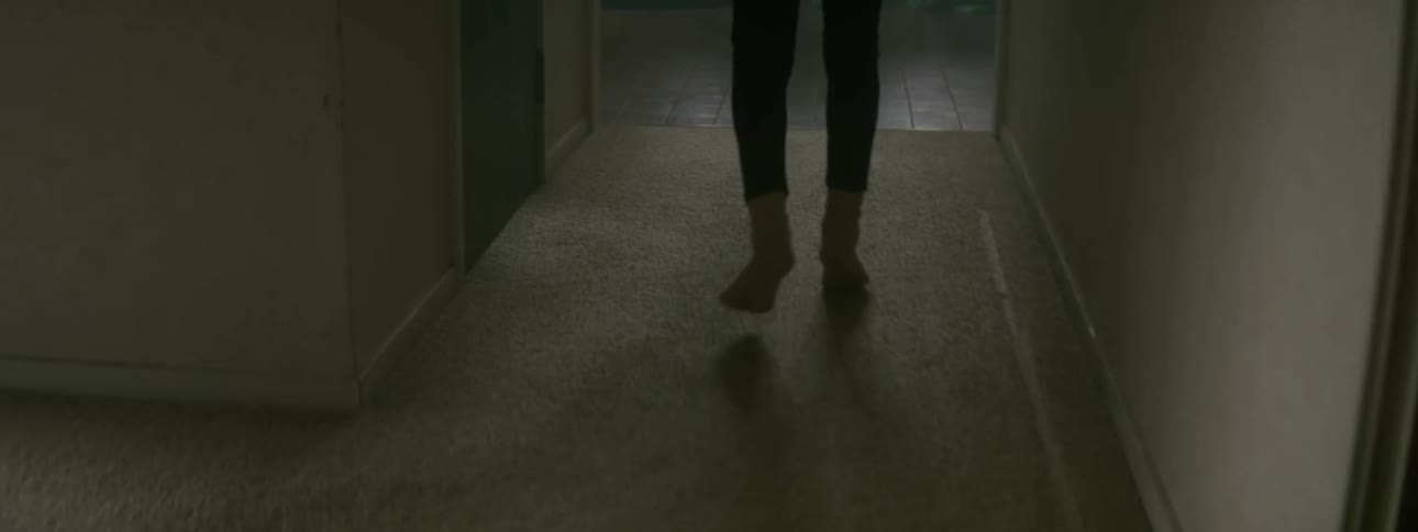 A girl runs down a hallway at home