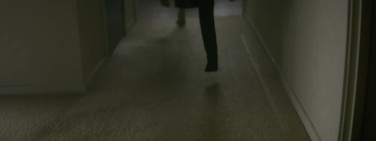 Two children skip down the hallway of their house