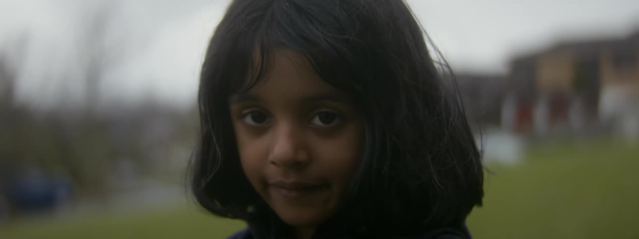 A female child is standing outdoors during spring