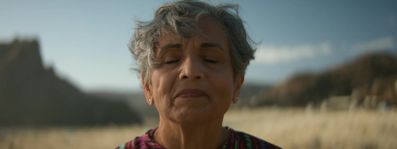 Woman meditates outdoors with mesa in the background