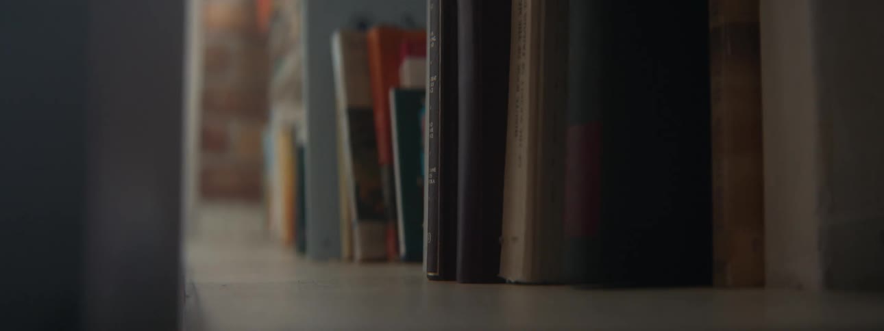 Woman pulling out and old book from a bookshelf