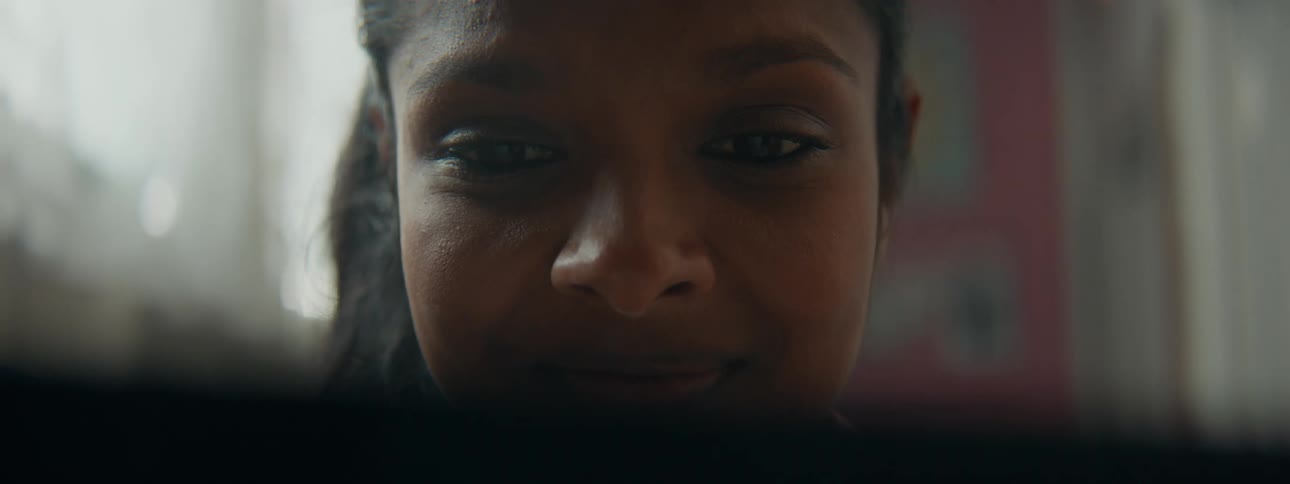 A woman is looking down at something with a smile on her face