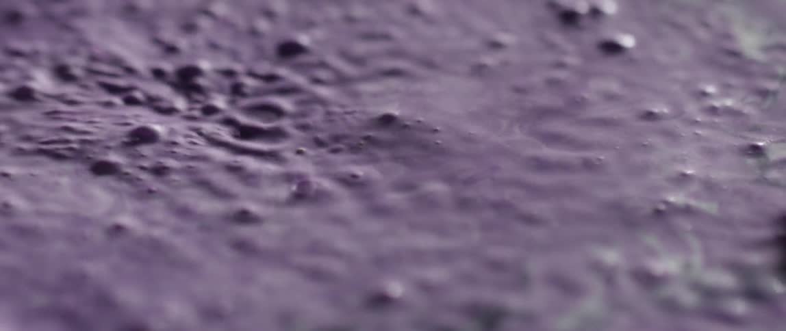 A purple liquid bounces and vibrates