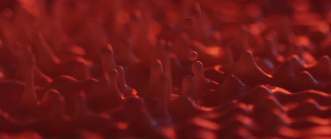 Red liquid vibrating small bubbles splattering upwards