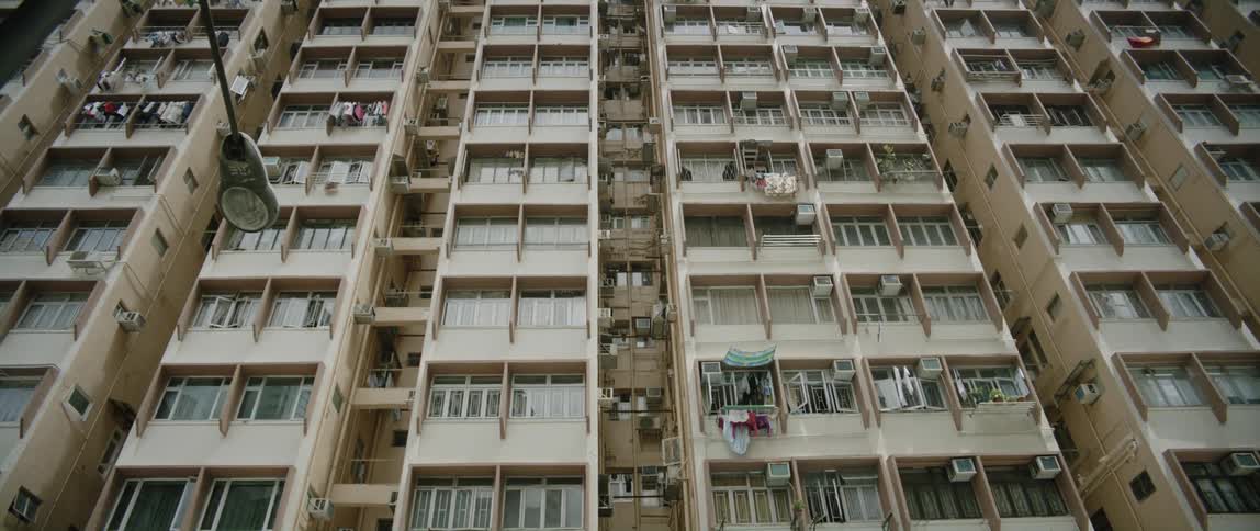 Looking up at a high rise apartment building with clothes hanging out on the balconies