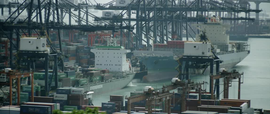 Several cargo ships in port being loaded and unloaded
