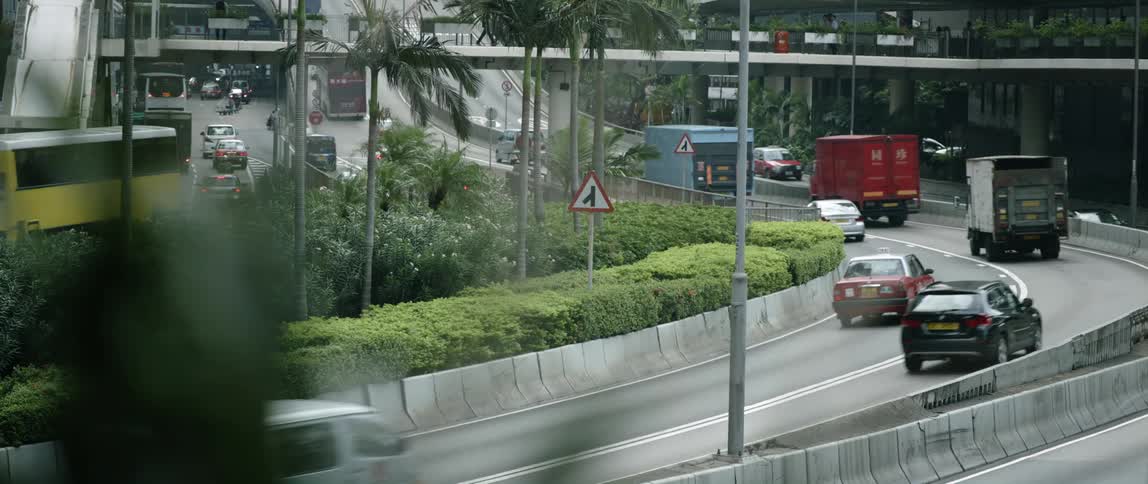 A roadway running through an urban environment is filled with vehicular traffic