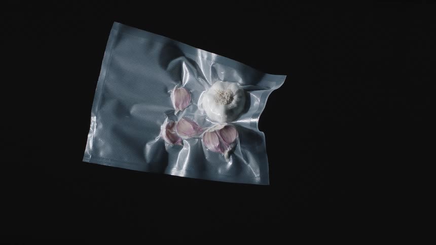 Garlic cloves and a garlic head are encased in a vacuum sealed plastic