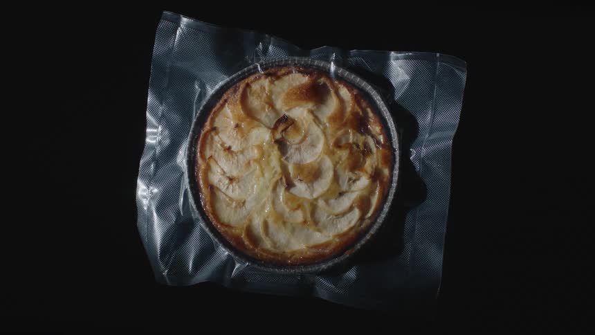 A pie sitting on plastic wrap in a studio