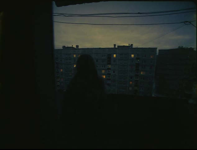 A woman is walking through a building in a city at night