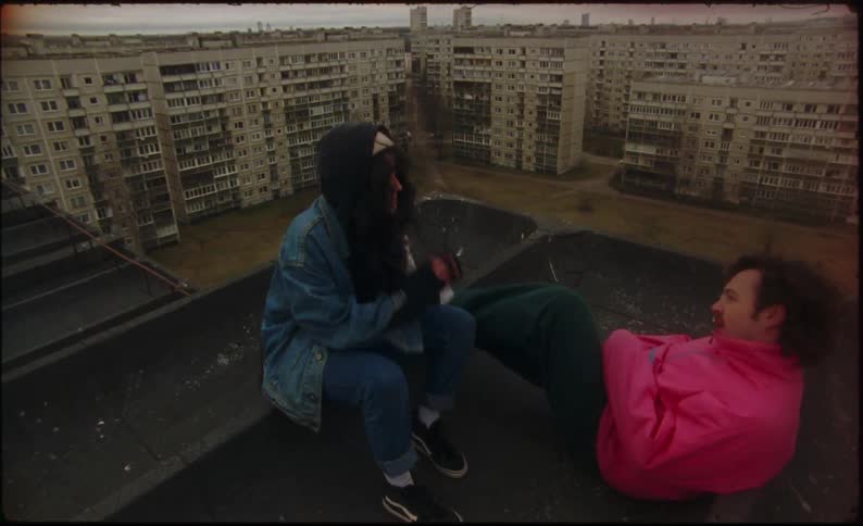 Two people sitting on top of a building outdoors