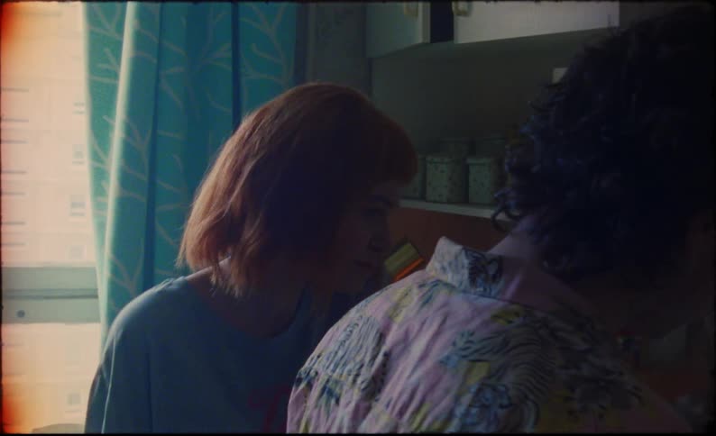 A woman goes into the kitchen to watch her boyfriend cook