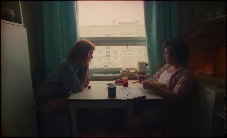 A man and woman are eating at the table