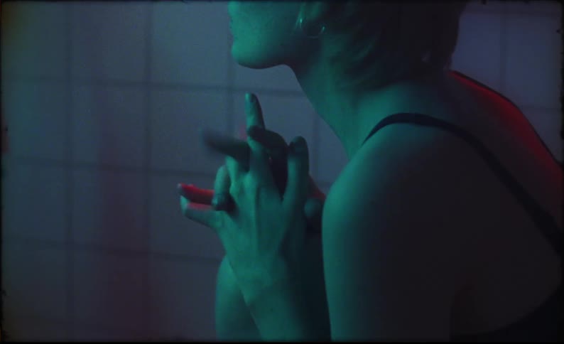 A woman sitting with her hands clasped keeps a musical beat with her fingers