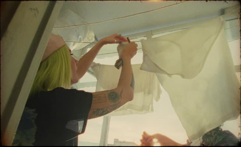 Young couple hang clothes to dry near a window in an apartment at morning
