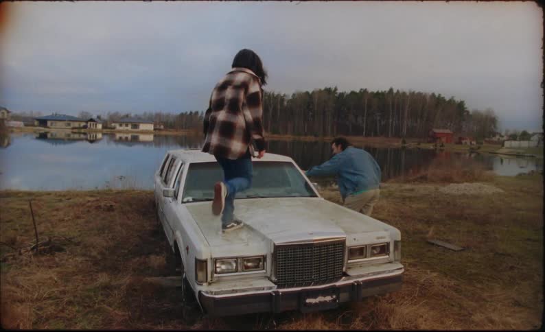 Woman and man are in a rural area near their vehicle
