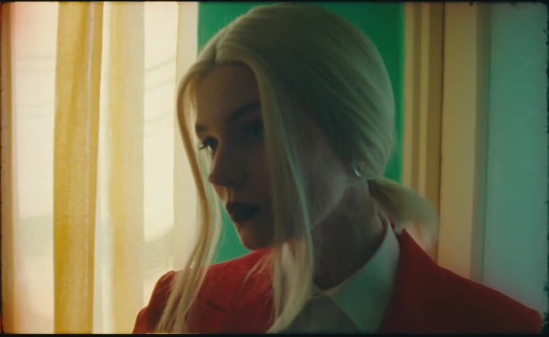 A woman starts to open a door but turns around and poses
