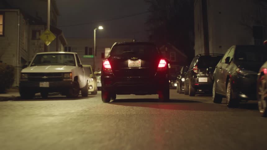 Cars are driving down the road at night time