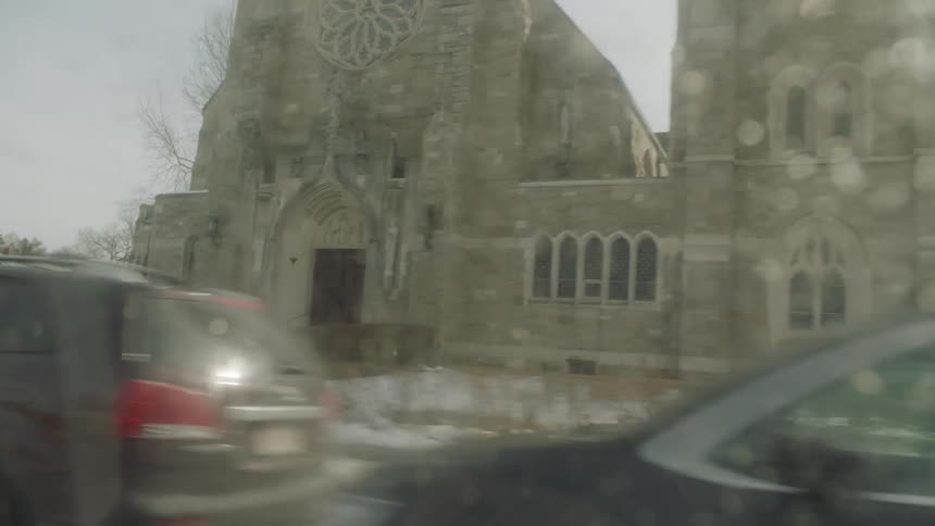 A crowd of people are standing outside of a church